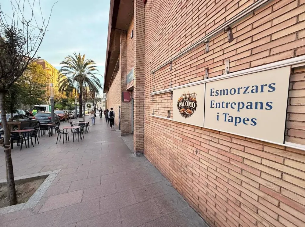 Façana del mercat amb el rètol del Bar Palomo i la terrassa